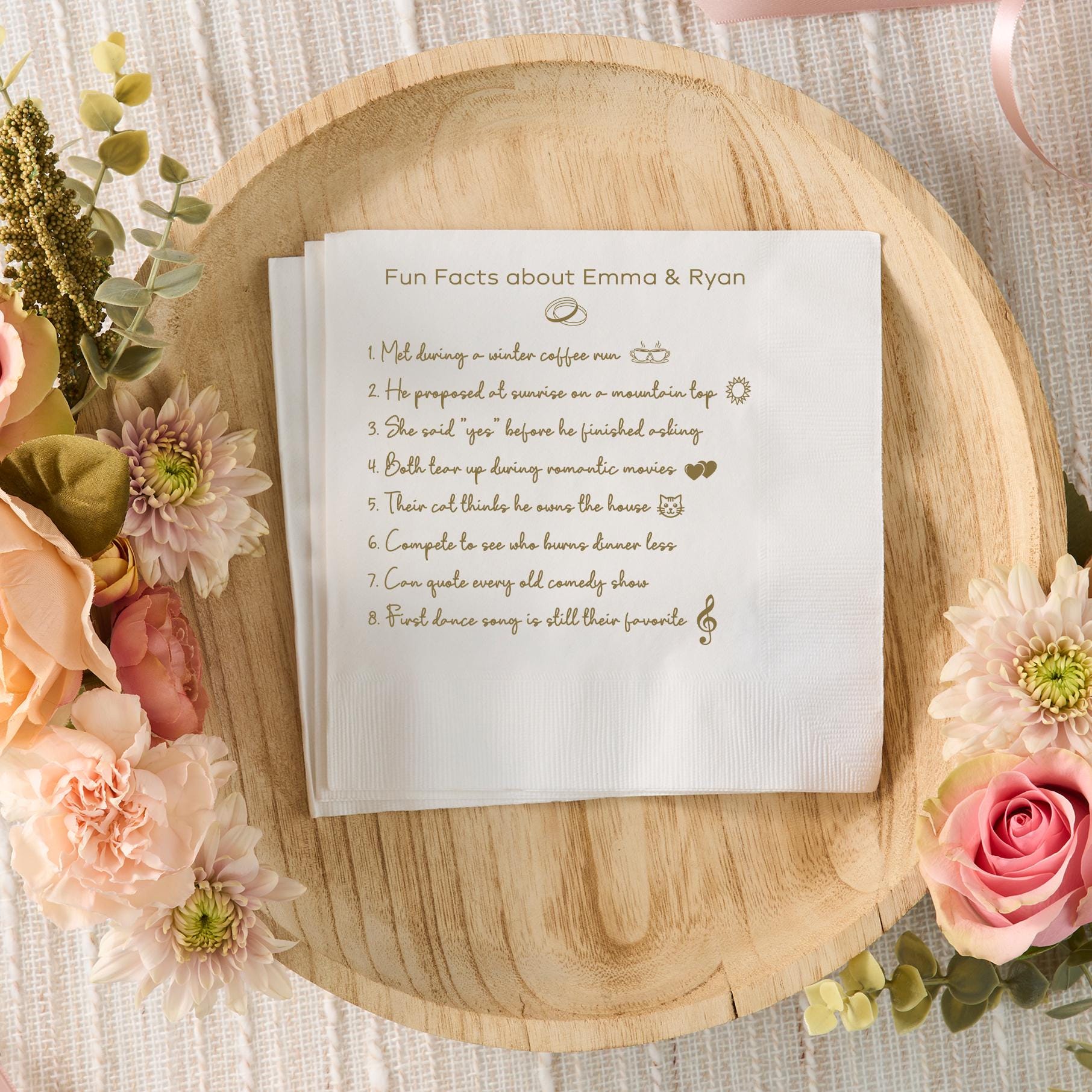 Personalized wedding fun facts napkins with gold printed trivia about the couple — custom cocktail napkins for wedding, engagement party, or anniversary reception.