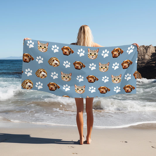 This custom pet-themed beach towel features adorable pet faces and paw prints on a blue background, making it a perfect personalized accessory for dog and cat lovers.